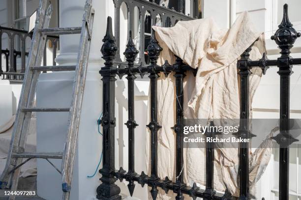 Dust sheets air on railings as a decorating contractor paints the exterior of a white property in South Kensington, on 19th October 2022, in London,...