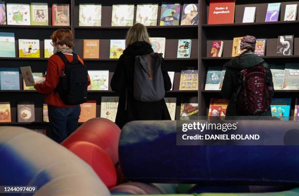 Visitors look at books displayed at the stand of Spain, this year's Guest of Honor, at the Frankfurt Book Fair at the Messe fairground in Frankfurt...