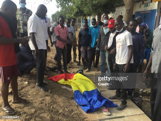 Graphic content / A body covered by a Chadian flag is shown by demonstrators in NDjamena on October 20, 2022 during a protest. - Five people "died...