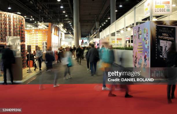 Visitors walk between stands at the Frankfurt Book Fair at the Messe fairground in Frankfurt am Main, western Germany, on October 20, 2022. - The...