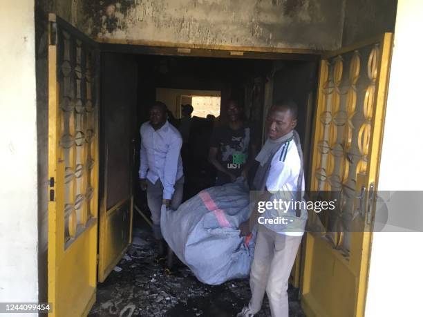 Supporters of the "Union Nationale pour le Developpement et le Renouveau" salvage items after their headquarters were set alight in NDjamena on...