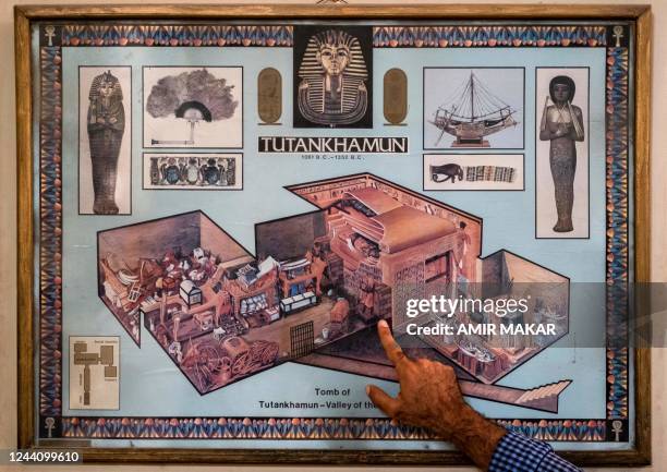 Tour guide briefs tourists before an illustration showing the state of KV62, the tomb of the ancient Egyptian New Kingdom Pharaoh Tutankhamun -- at...