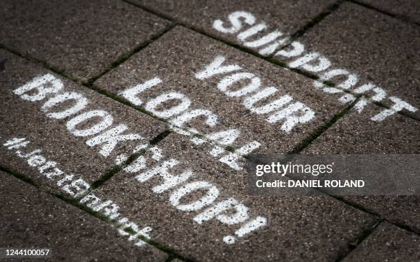 The lettering 'Support your local bookshop' is seen written on the pavement during the Frankfurt Book Fair at the Messe fairground in Frankfurt am...