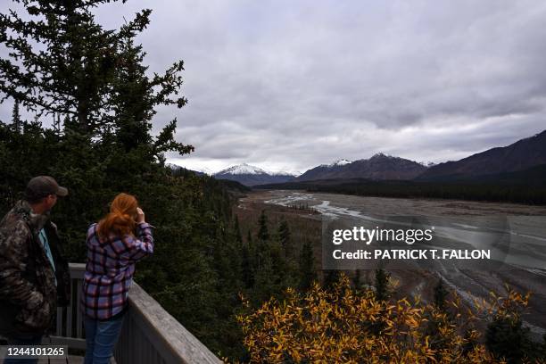 Visitors look at the Teklanika River from the Teklanika rest area at Mile 30 on the park road in Denali National Park in Denali, Alaska on September...