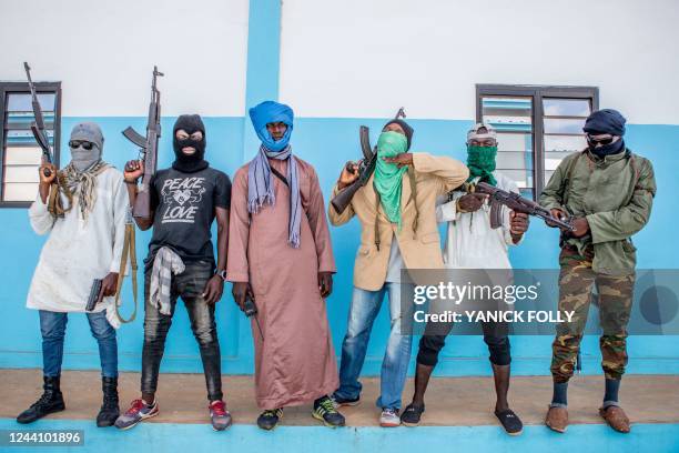 Togolese policemen, disguised as a terrorists, hold their weapons on October 20, 2022 as they take part in an anti-terrorism exercise at the...