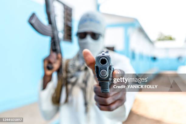 Togolese policeman, disguised as a terrorist, brandishes his weapon on October 20, 2022 during an anti-terrorism exercise at the Peacekeeping...