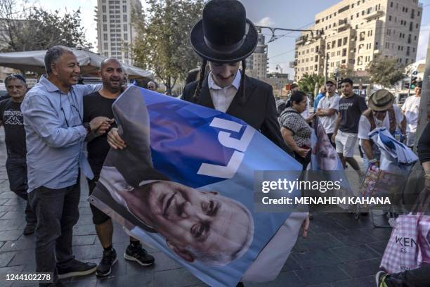 An Ultra-orthodox Jewish man holds a poster bearing a portrait of former Israeli prime minister and Likud party leader Benjamin Netanyahu, during a...