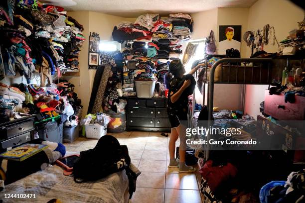 Angie Davila the oldest of six children, organizes her belongings on top bunk bed in the family's one-bedroom apartment in the Pico-Union...