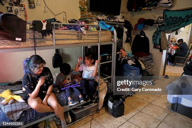 Angie Davila left, the oldest of six children, plays video games with youngest siblings Lino Galicia and Yaretzi Galicia on the bunk beds in the...