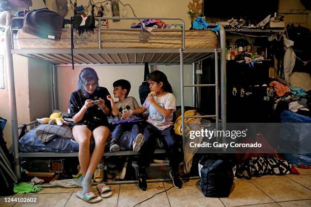 Angie Davila left, the oldest of six children, plays video games with youngest siblings Lino Galicia and Yaretzi Galicia on the bunk beds in the...