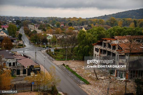 Local residents ride bicycles as damaged buildings are seen in Svyatohirs'k, Donetsk region, on October 20 after the liberation of the area.