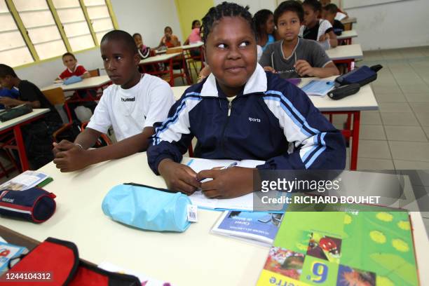 Des enfants posent, le 21 août 2007, à Le Port, dans l'ouest de l'île de la Réunion, jour de la rentrée scolaire pour les écoliers, collégiens et...