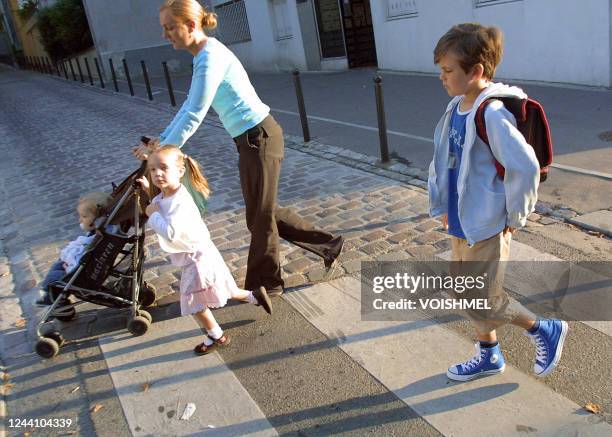 Thomas , 7 ans, et Selma , 4 ans, vont à l'école accompagnés de leur maman et de leur petit frère le 02 septembre 2005 à Paris pour le premier jour...