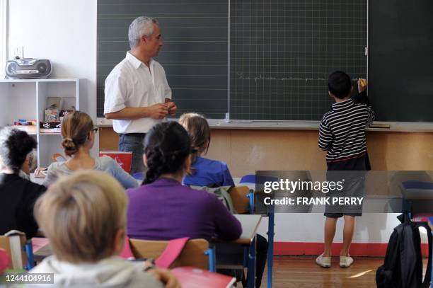 Un élève écrit sur le tableau noir, dans l'une des classes de l'école Harouys à Nantes, le 05 septembre 2011, jour de la rentrée scolaire. Plus de 12...