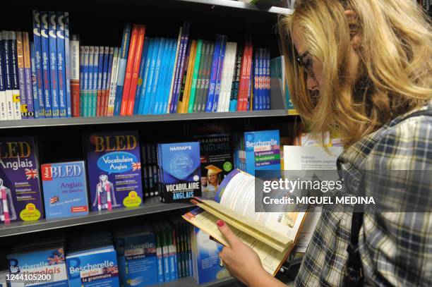 Une femme consulte un livre, le 16 août 2010, dans une librairie à Paris. L'Union des familles en Europe a réclamé ce jour que le coût de la rentrée...