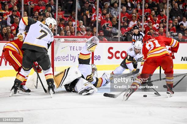 Calgary Flames Center Nazem Kadri tries to score on a sprawling Vegas Golden Knights Goalie Logan Thompson during the second period of an NHL game...