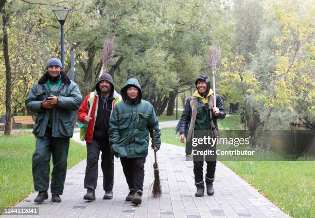 Work migrants from former Soviet republics of Central Asia holding brooms walk in the park, October 17 in Moscow, Russia. President Vladimir Putin's...