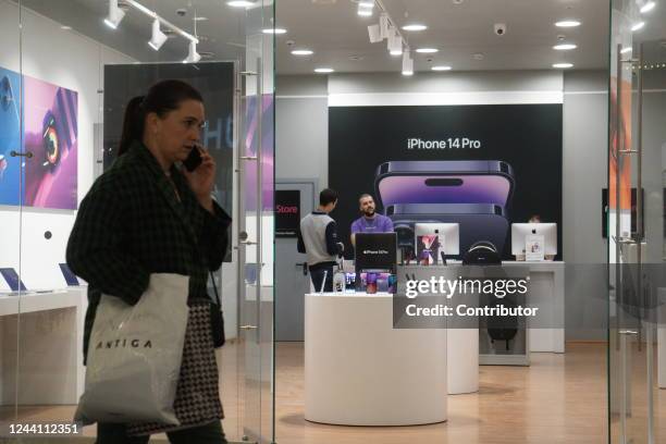 Woman walks past the store that advertises a new Apple iPhone 14 pro, at a shopping mall, on October 20 in Moscow, Russia. President Vladimir Putin's...