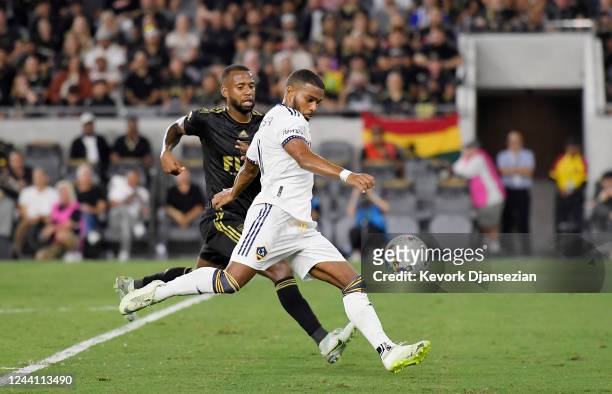 Samuel Grandsir of Los Angeles Galaxy shoots and scores a goal against Kellyn Acosta of Los Angeles FC during the first half of the Western...
