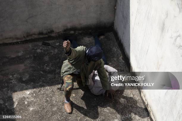 Togolese policeman disguised as "terrorist" pretends to stab another policeman disguised as civilian during a simulation exercise on October 20, 2022...