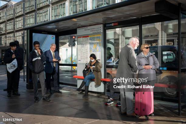 Elderly passengers queue ahead of younger travellers at a bus stop on Victoria Street in central London, on 20th October 2022, in London, England.
