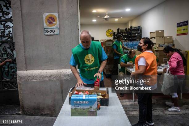 Volunteer packs a crate of groceries at a food bank, operated by El Gra de Blat and La Caixa charities, in the Sants district of Barcelona, Spain, on...
