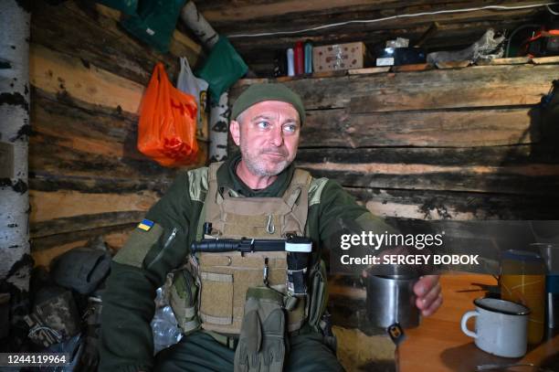 Soldier of the National Guard of Ukraine drinks tea in a dugout in the northern liberated territories of Kharkiv region on October 21 amid the...