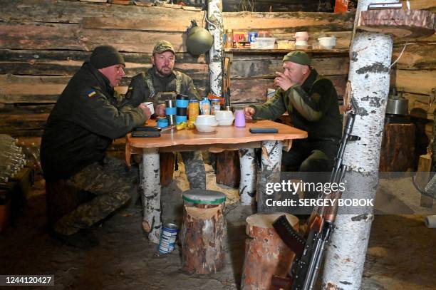 Soldiers of the National Guard of Ukraine share their tea in a dugout in the northern liberated territories of Kharkiv region on October 21 amid the...