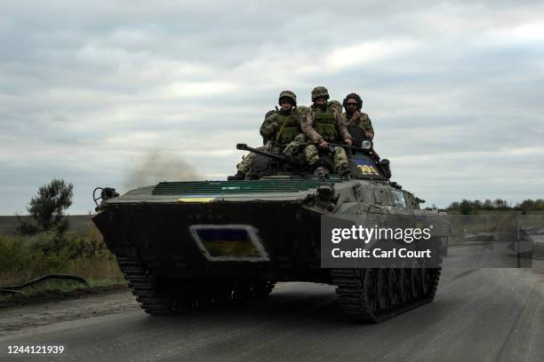 Ukrainian soldiers ride on top of an armoured fighting vehicle towards the front line on October 21, 2022 in Bakhmut, Donetsk oblast, Ukraine....