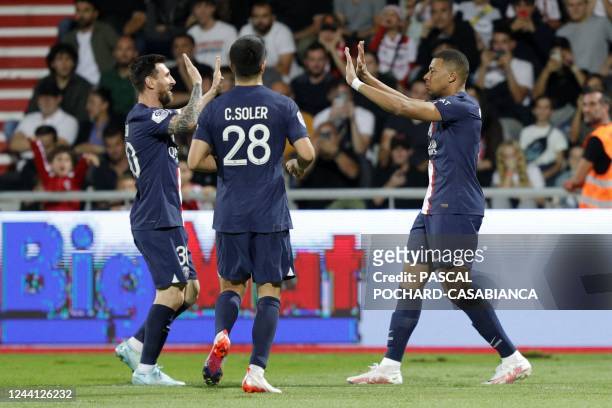 Paris Saint-Germain's French forward Kylian Mbappe celebrates with teammates after scoring a goal during the French L1 football match between AC...