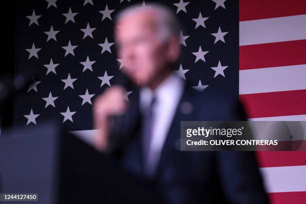 The US flag iseen behind US President Joe Biden as he speaks about student debt relief at Delaware State University in Dover, Delaware, on October...