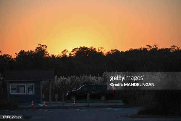 The SUV carrying US President Joe Biden is seen under a setting sun after Biden arrived at Gordons Pond in Cape Henlopen State Park in Lewes,...