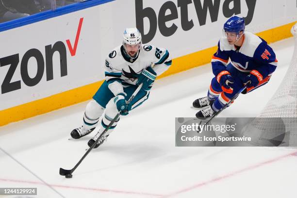 San Jose Sharks Defenseman Erik Karisson skates with the puck with New York Islanders Center Jean-Gabriel Pageau in pursuit during the first period...