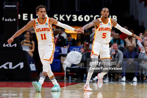 Trae Young reacts with Dejounte Murray of the Atlanta Hawks during the second half against the Orlando Magic at State Farm Arena on October 21, 2022...