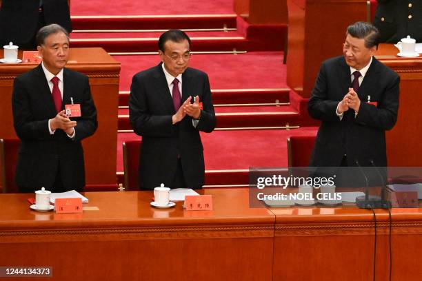 China's President Xi Jinping applauds beside Premier Li Keqiang and Politburo Standing Committee member Wang Yang during the closing ceremony of the...