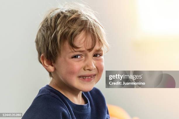 niño llorando mirando a la cámara - boy sad fotografías e imágenes de stock