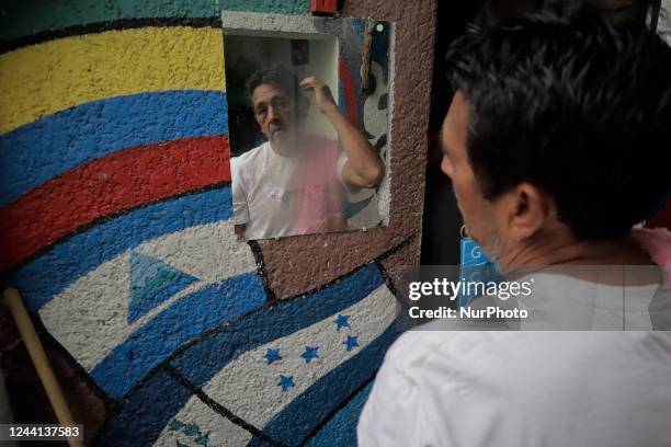 Venezuelan migrant combs his hair inside a shelter in Mexico City, who has left his country of origin for various political, economic and cultural...