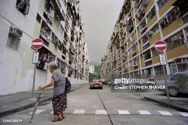 An old woman crosses a street of the massive Shep housing estates in Kowloon on June 12, 1997 at Hong Kong. - Hong Kong's chronic housing problems, a...