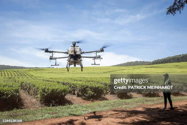 Kenya Airways employee controls an unmanned aerial vehicle as it spreads fertilizer over a tea farm at Kipkebe Tea Estate in Musereita on October 21,...