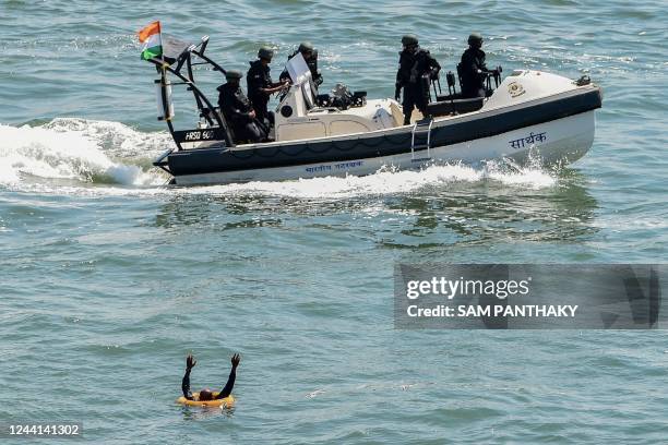 Indian Coast Guard personnel demonstrate their skills in a search and rescue drill as a part of a Defence exhibition, in Porbandar on October 22,...