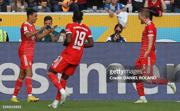 Bayern Munich's German midfielder Jamal Musiala celebrates scoring his team's first goal with team mates during the German first division Bundesliga...