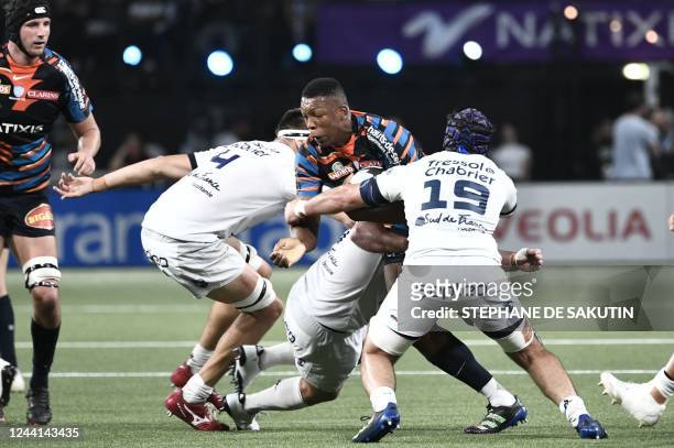 Racing92's French lock Cameron Woki is tackled by Montpellier's French lock Florian Verhaeghe and Montpellier's French flanker Clement Doumenc during...