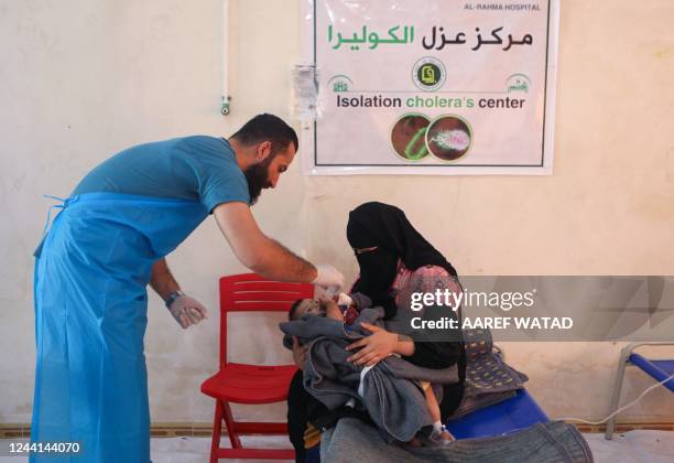 Medic treats a baby brought by his mother at a recently-opened medical center for Cholera cases in the Syrian town of Darkush, on the outskirts of...