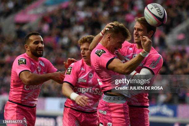 Stade Francais' French fly half Leo Barre celebrates with team mates after scoring a try during the French Top 14 rugby union match between Paris'...