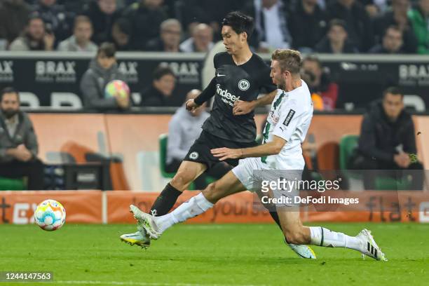 Daichi Kamada of Eintracht Frankfurt and Christoph Kramer of Borussia Moenchengladbach battle for the ball during the Bundesliga match between...