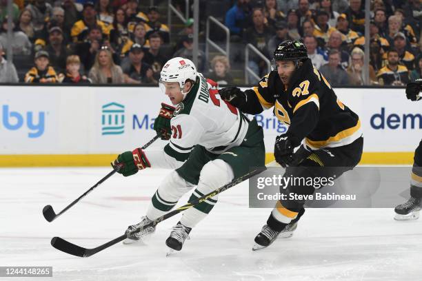 Brandon Duhaime of the Minnesota Wild skates against Patrice Bergeron of the Boston Bruins at the TD Garden on October 22, 2022 in Boston,...