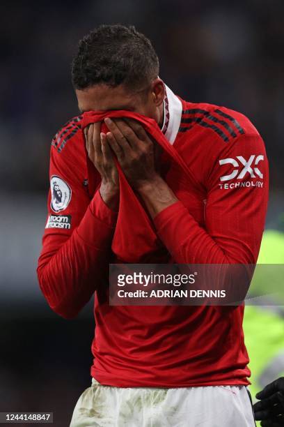 Manchester United's French defender Raphael Varane reacts as he leaves the pitch after picking up an injury during the English Premier League...