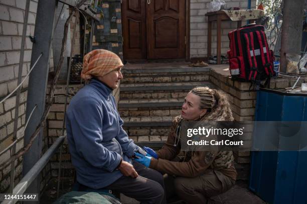 Army doctor Natalia Leliukh checks the pulse rate of village resident Natalia as she visits civilians in a recently liberated area on October 22,...