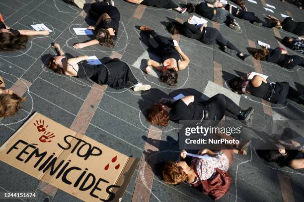 Women lie on the ground with sheets with the names and ages of women killed in 2022. Women from the collective NousToutes organized a die-in Toulouse...