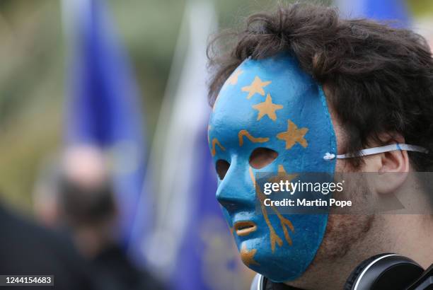 An EU supporter wears an EU flag painted mask as he joins the march in Park Lane on October 22, 2022 in London, United Kingdom. Protesters implore...